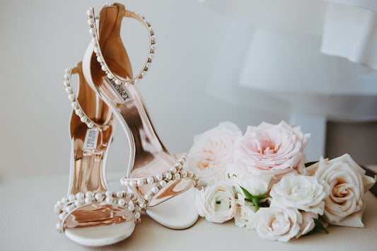 A bridal shoe and bouquet of flowers on a table