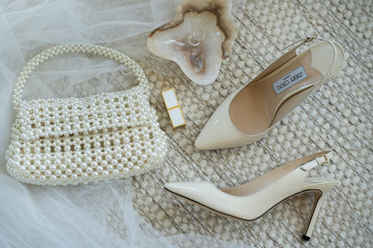 A pair of shoes and a purse on a bed