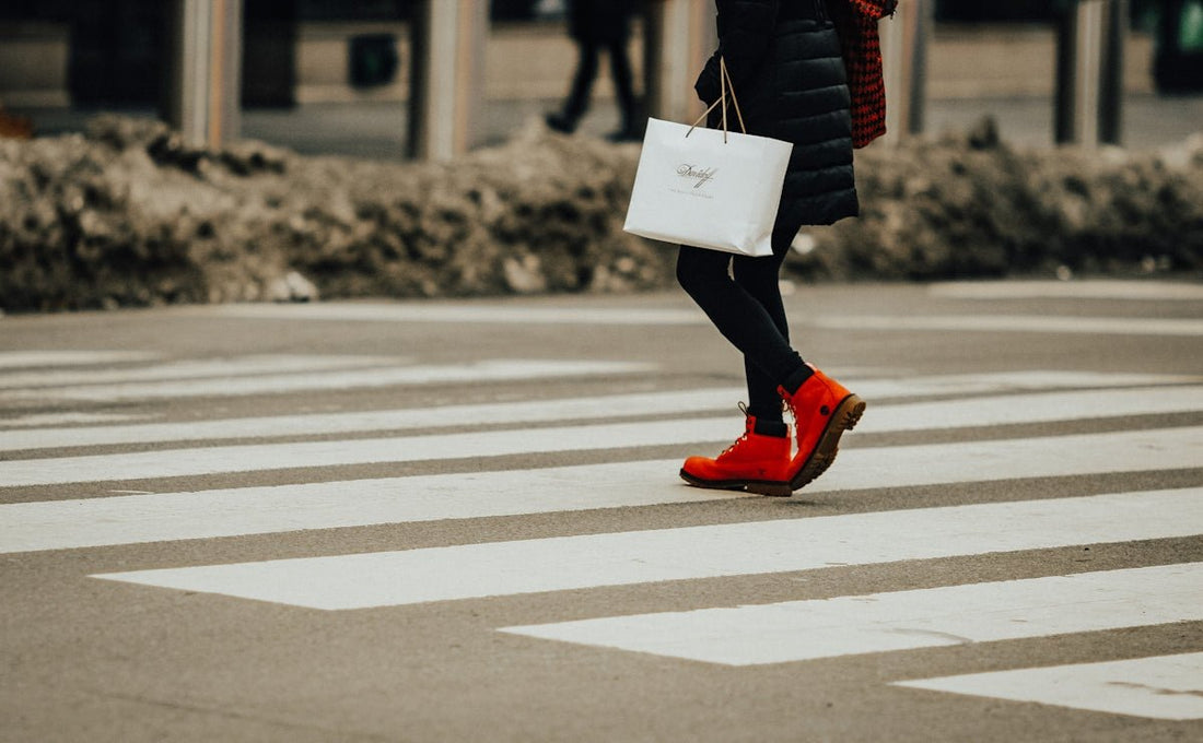 person in black jacket and red pants walking on pedestrian lane during daytime