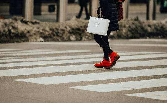 person in black jacket and red pants walking on pedestrian lane during daytime