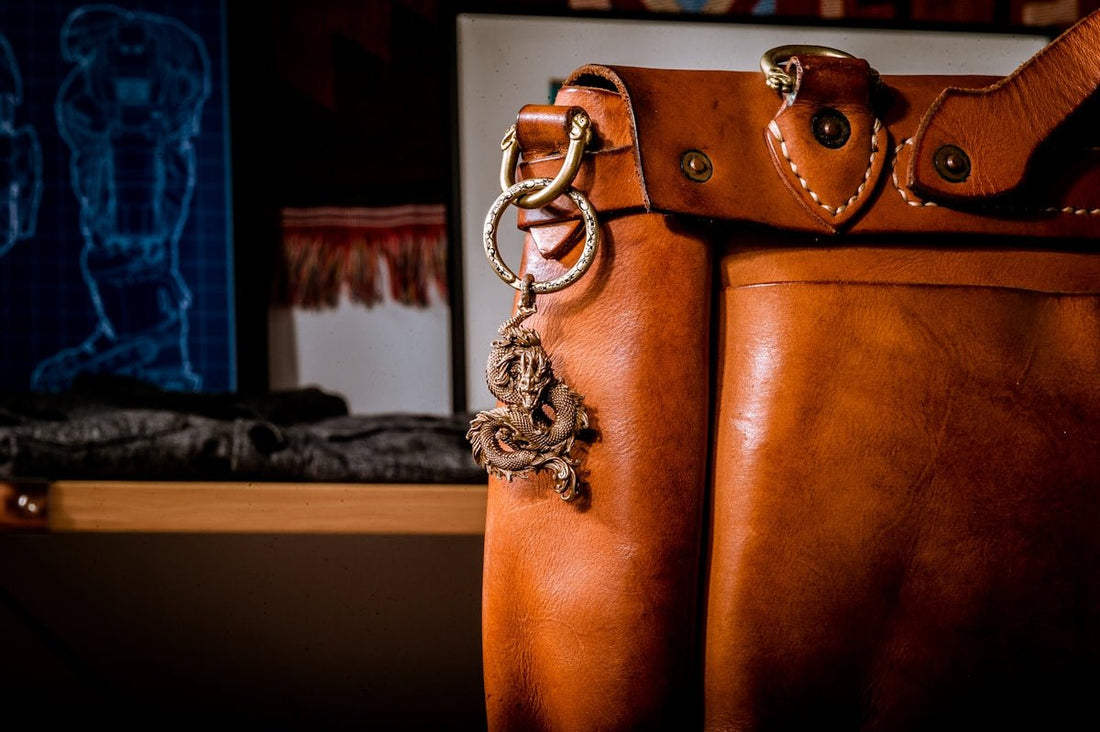 a brown leather bag with a chain hanging from it