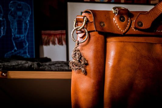 a brown leather bag with a chain hanging from it