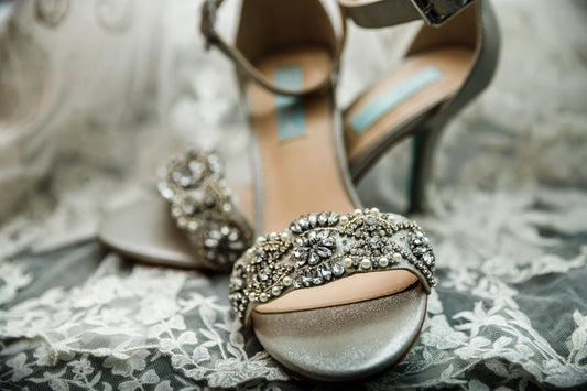 a pair of high heeled shoes sitting on top of a bed