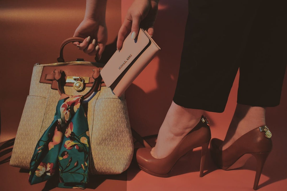woman in black dress holding white leather handbag