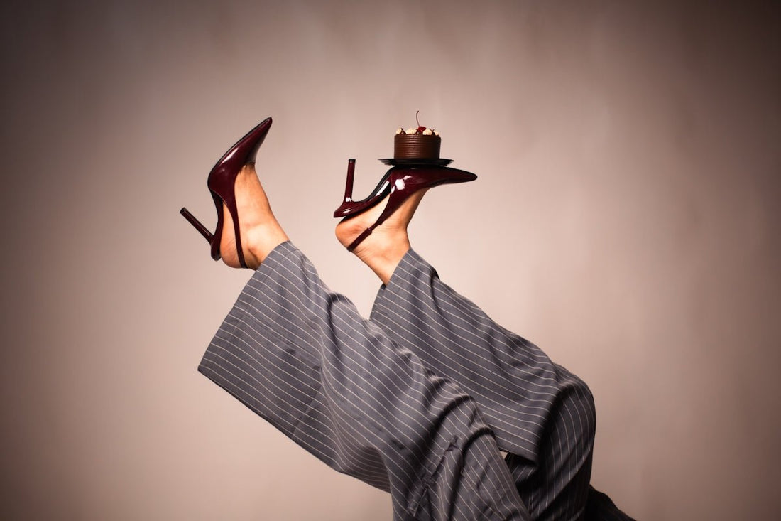 Woman's legs wearing heels and pants with cake.