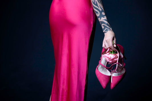 a woman in a pink dress holding a pink purse