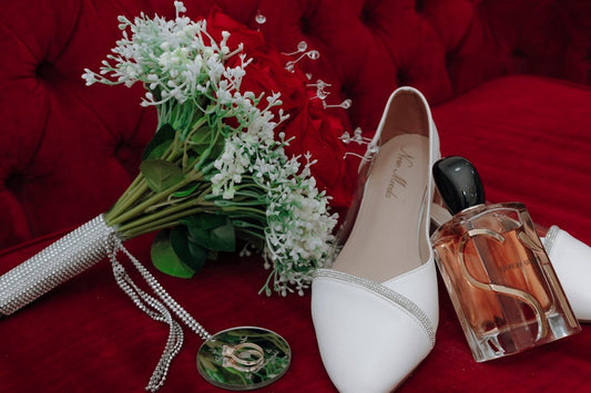 A bouquet of flowers and a pair of shoes on a red couch