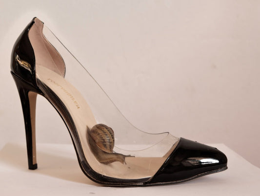 a pair of black high heels with a butterfly on the heel