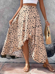 Woman wearing a light apricot skirt with black spots against a gray wall.