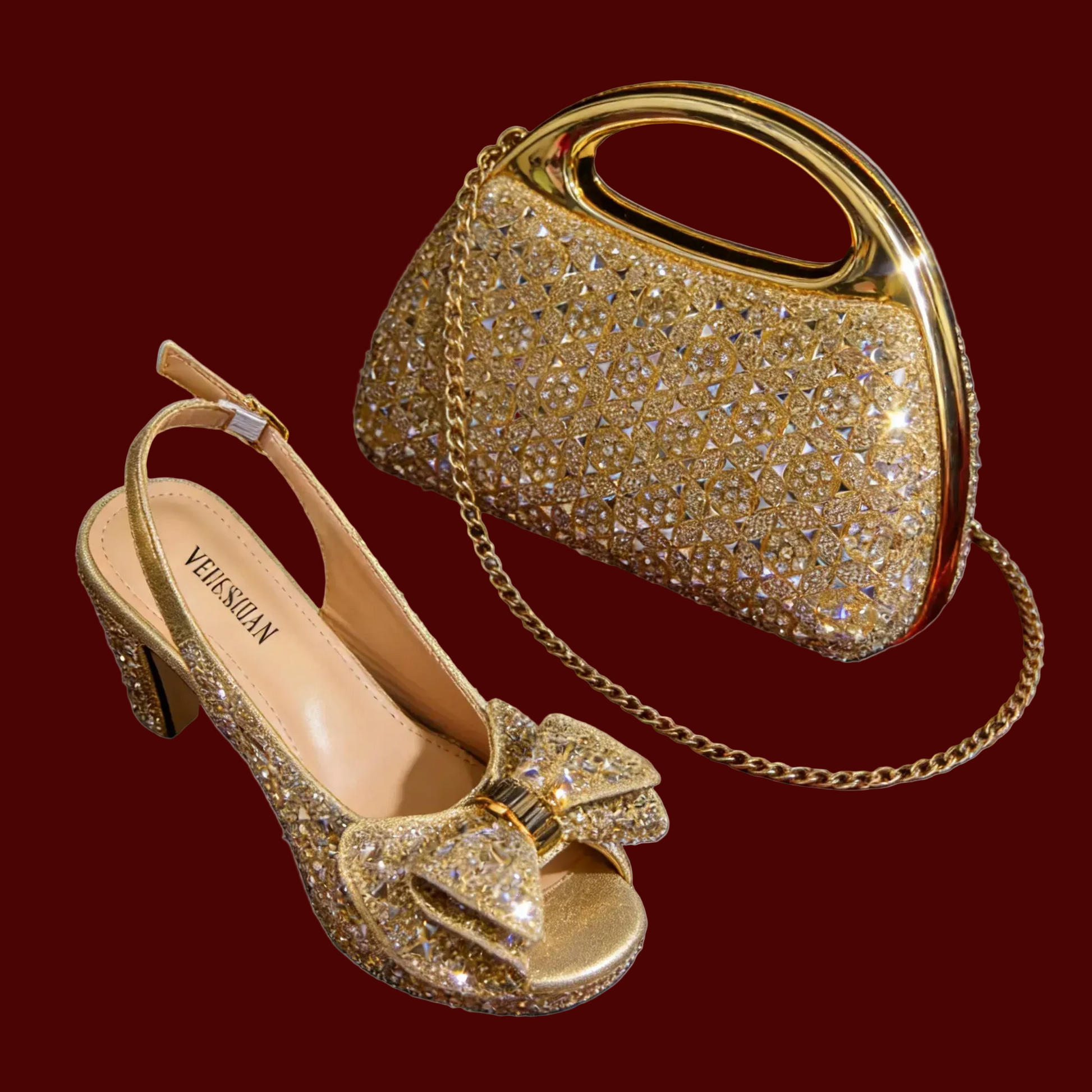 A gold rhinestone-embellished slingback high heel shoe and a matching handbag with a gold chain strap, shown on a plain maroon background.