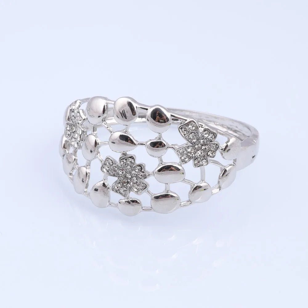 Silver ring with floral designs on a light gray background