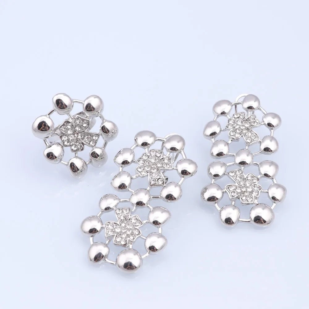 Set of silver floral earrings and a ring on a light purple background