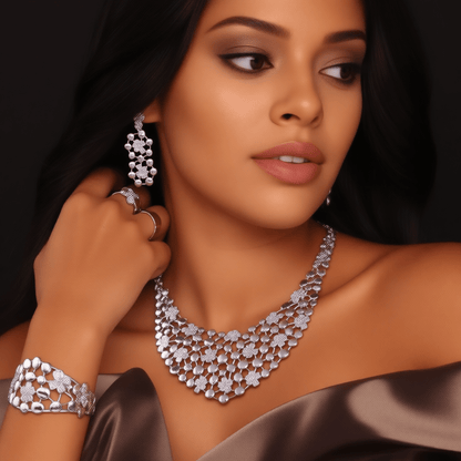 A close-up glam portrait of a stylish, beautiful, female model wearing the full elegant Dubai silver-plated jewelry set: intricate necklace, matching bracelet, matching dangling earrings, and matching ring—all worn together