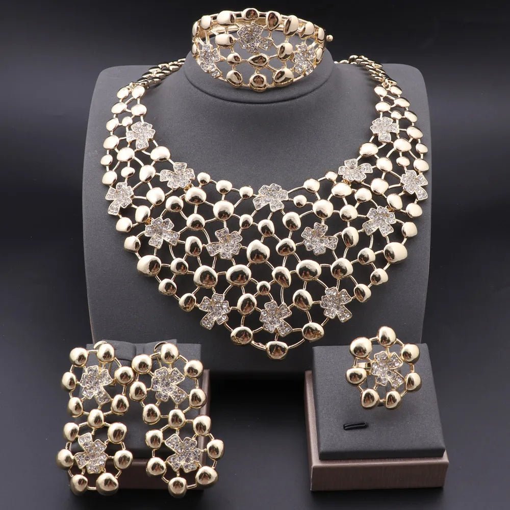 Gold jewelry set including necklace, bracelet, ring and earrings on a black background