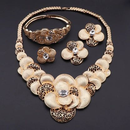 Gold necklace, bracelet, ring, and earrings set on a dark background