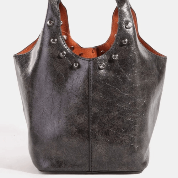 Black fame weathered faux leather and studs bucket bag on a white background