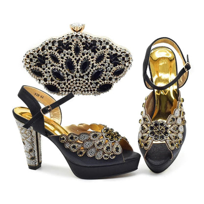 Black high-heeled shoes with gold and crystal embellishments and a matching clutch on a white background