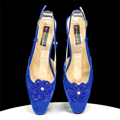 Pair of blue Italian Rhinestone Heels | Elegant Wedding with floral designs on a black background