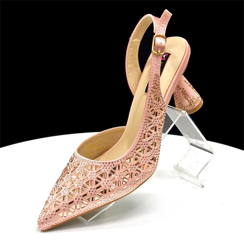 Champagne high-heeled Italian shoes with intricate design on a clear stand against a black background