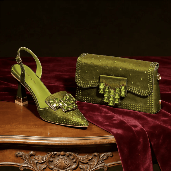 Olive Green high-heeled shoe and matching handbag on a wooden table with a dark background