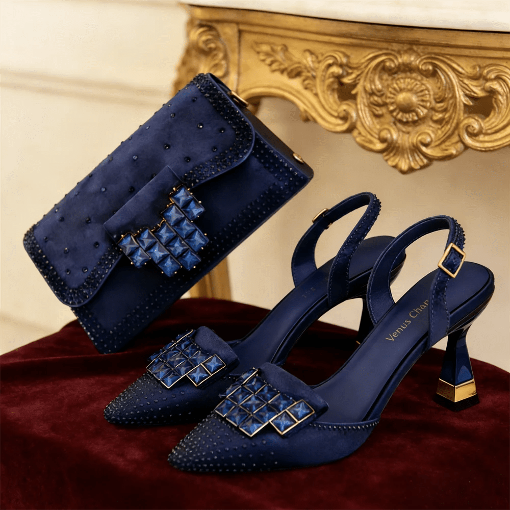 Mineral blue shoes and matching handbag with rhinestone decor on a red surface.