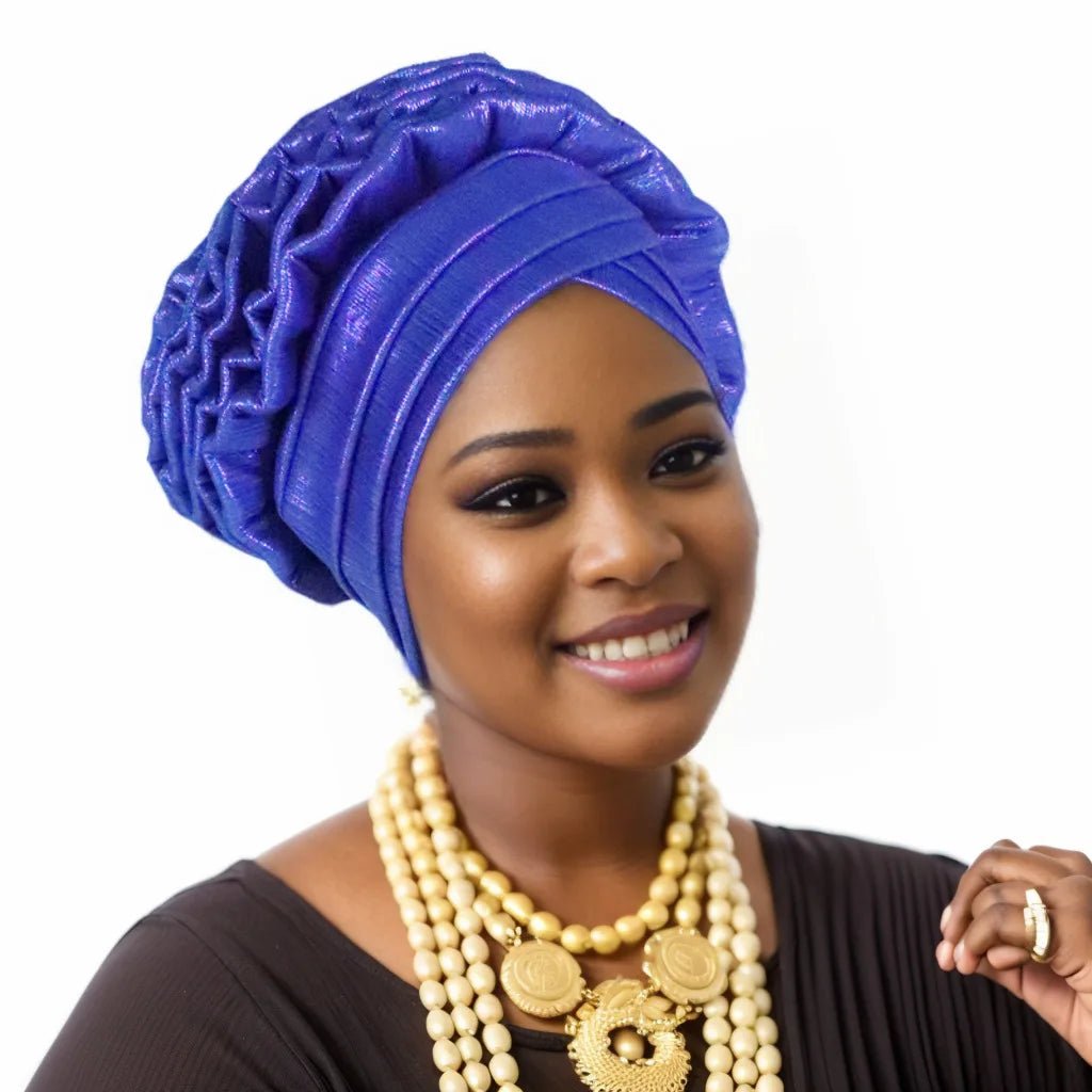 Woman wearing a blue Nigerian auto gele headwrap on a white background