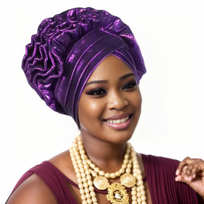 Woman wearing a purple Nigerian auto gele headwrap on a white background