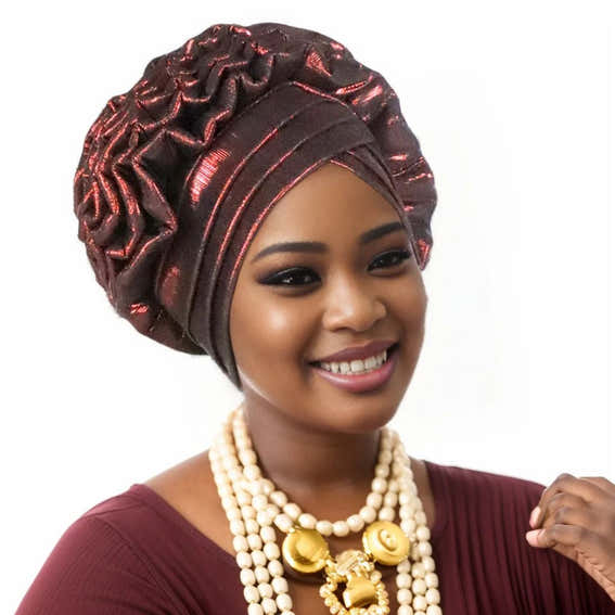 Woman wearing a wine red Nigerian auto gele headwrap on a white background