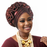 Woman wearing a wine red Nigerian auto gele headwrap on a white background