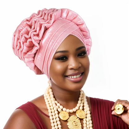 Woman wearing a pink Nigerian auto gele headwrap on a white background