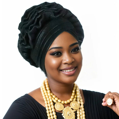 Woman wearing a black Nigerian auto gele headwrap on a white background