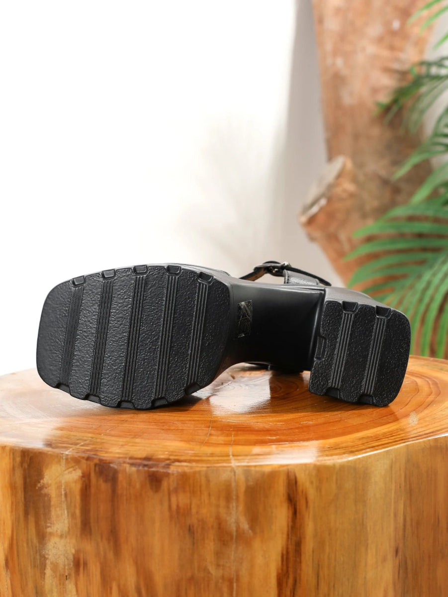 Black sandals with thick soles on a wooden surface