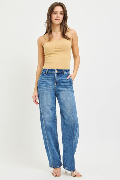 an attractive female model wearing the blue baggy jeans against a white background