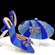 Blue high-heeled shoes with matching clutch on a clear stand against a black background